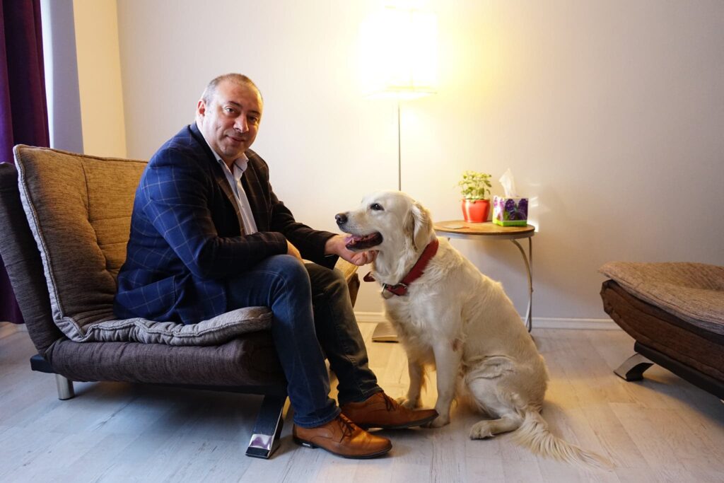 Florian Koleci, een Roemeense psychiater, in zijn kantoor met de hond van een cliënt. Foto: Florian Koleci 2022