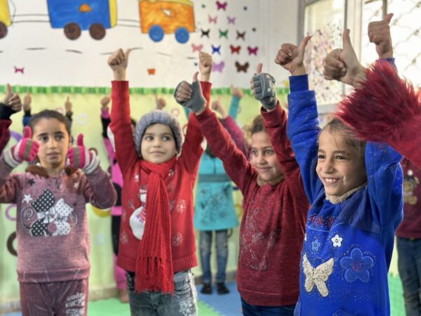 Kinderen werden geholpen met psychosociale activiteiten.